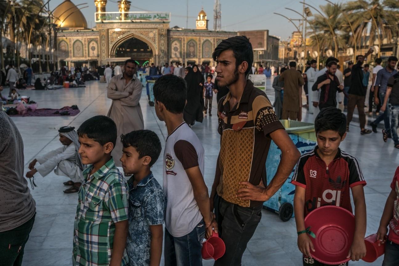  Pilgrims waiting for food and water to be distributed before evening prayer in Karbala, a holy city for Shiites. 