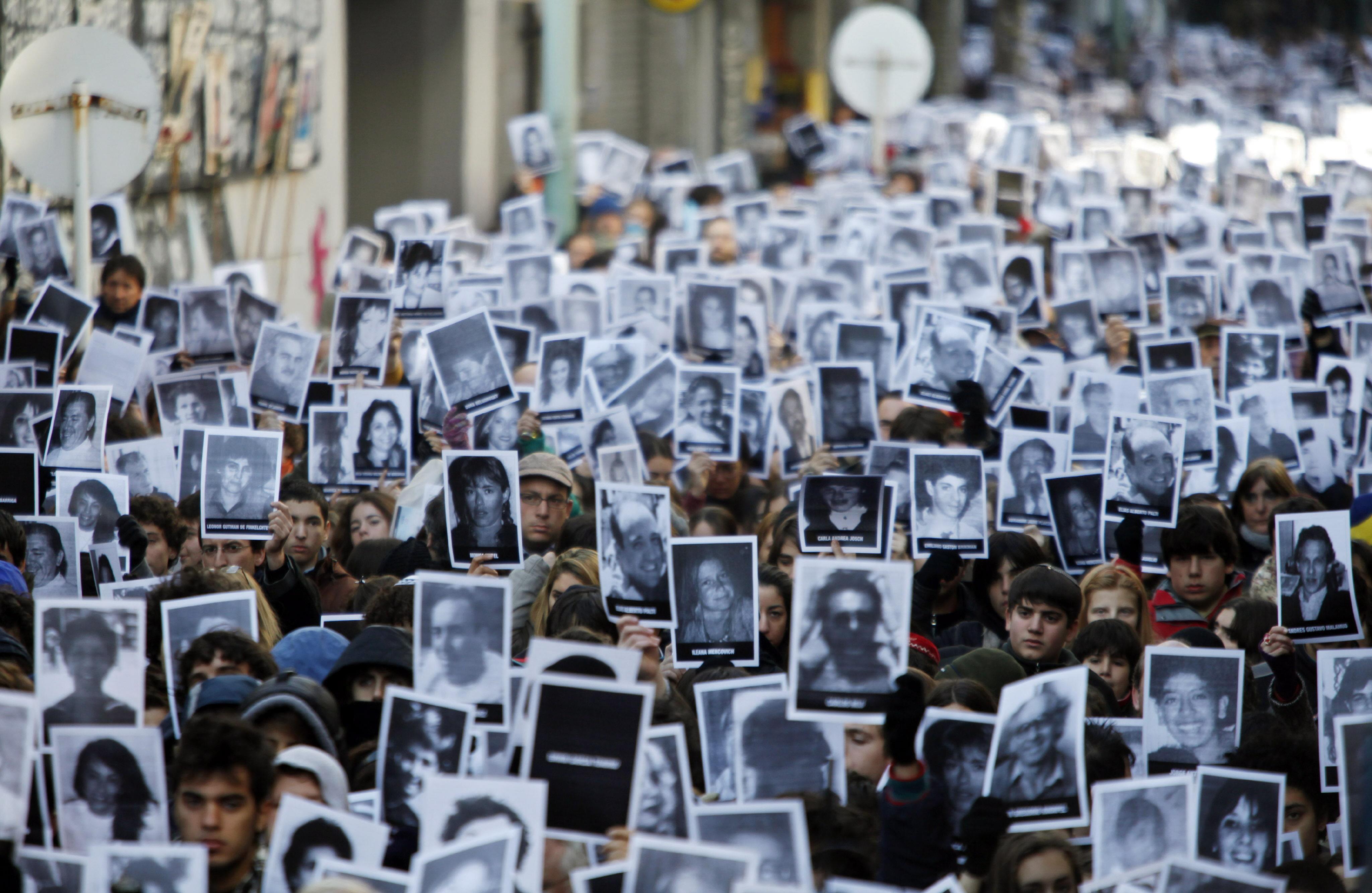 People holding photographs of the victims of the 1994 AMIA bombing participate at the ceremony to mark the 16th anniversary of this henious act that killed 85 people in Buenos Aires