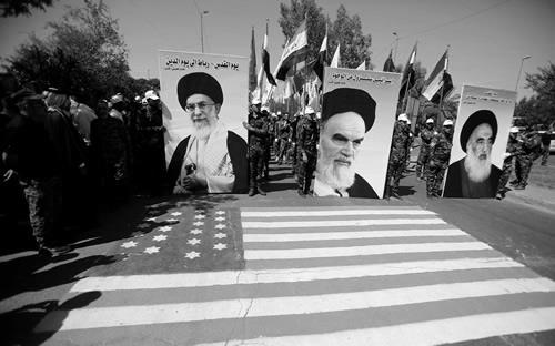 Members of Popular Mobilization hold portraits of Ayatollah Khomeini (C), Supreme Leader Ayatollah Ali Khamenei (L) and Iraq’s top Shi’ite cleric Grand Ayatollah Ali al-Sistani during a parade marking the annual al-Quds Day in Baghdad on June 23, 2017.