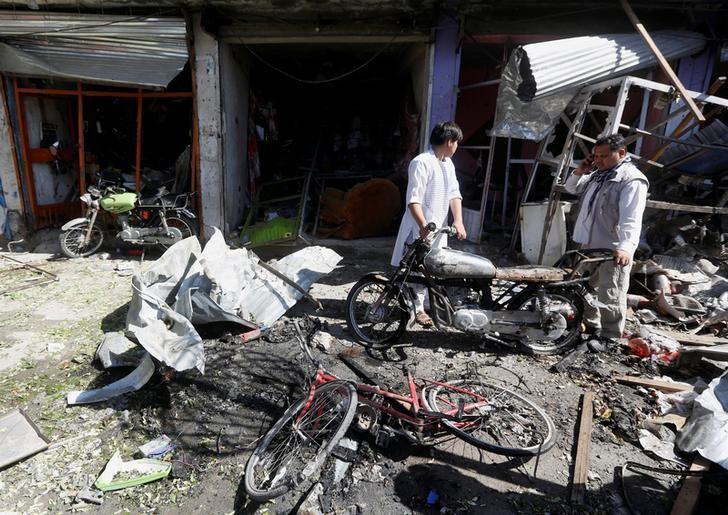 Afghan shopkeepers collect reamains in front of a shop after a suicide attack in Kabul, Afghanistan. July 24, 2017