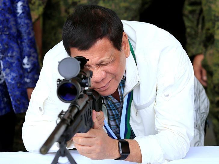 Philippines President Rodrigo Duterte checks the scope of a 7.62mm sniper rifle