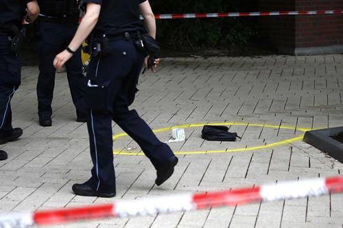 A police officer walks past crime scene after a knife attack in a supermarket in Hamburg.