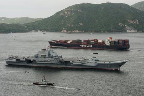 China's aircraft carrier Liaoning sails past a cargo ship as it arrives in Hong Kong