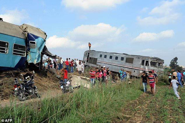 People gather at the site of a train collision near Egypt's Mediterranean city of Alexandria