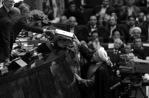 Hasan Rowhani delivering his cabinet list to Parliament Speaker Ali Larijani after he was sworn in before parliament in Tehran on August 4, 2013. 