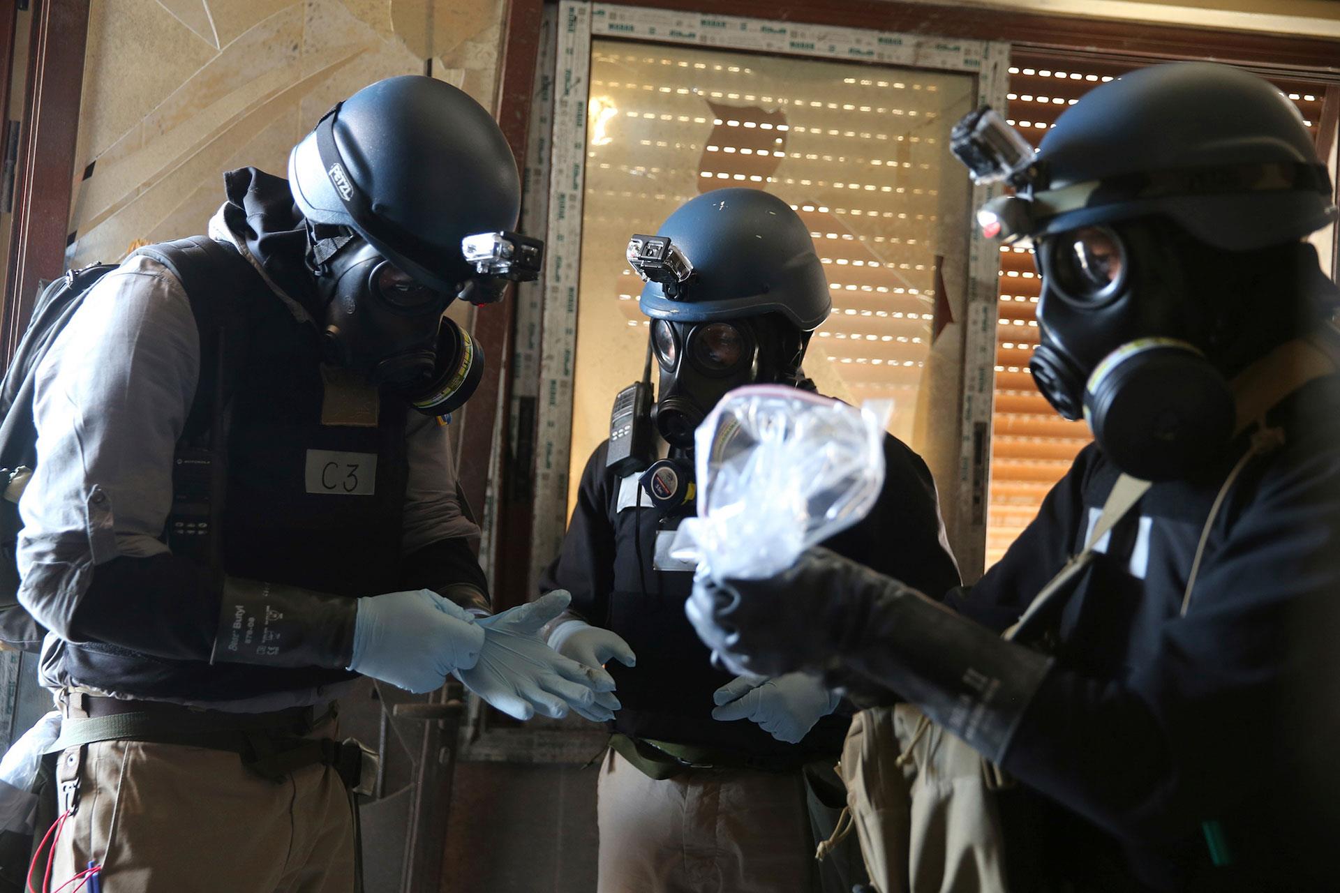A U.N. chemical weapons expert holds samples from one of the sites of a chemical weapons attack in the Ain Tarma neighbourhood of Damascus in August, 2013