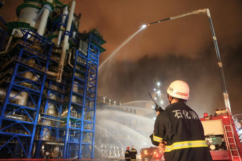 Firefighters spray water onto a fire at state oil major PetroChina's plant in Dalian, Liaoning province, China August 17, 2017