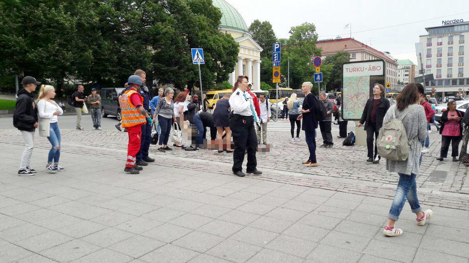 People gather to help a person who was attacked by a knifeman on Friday afternoon in Finland