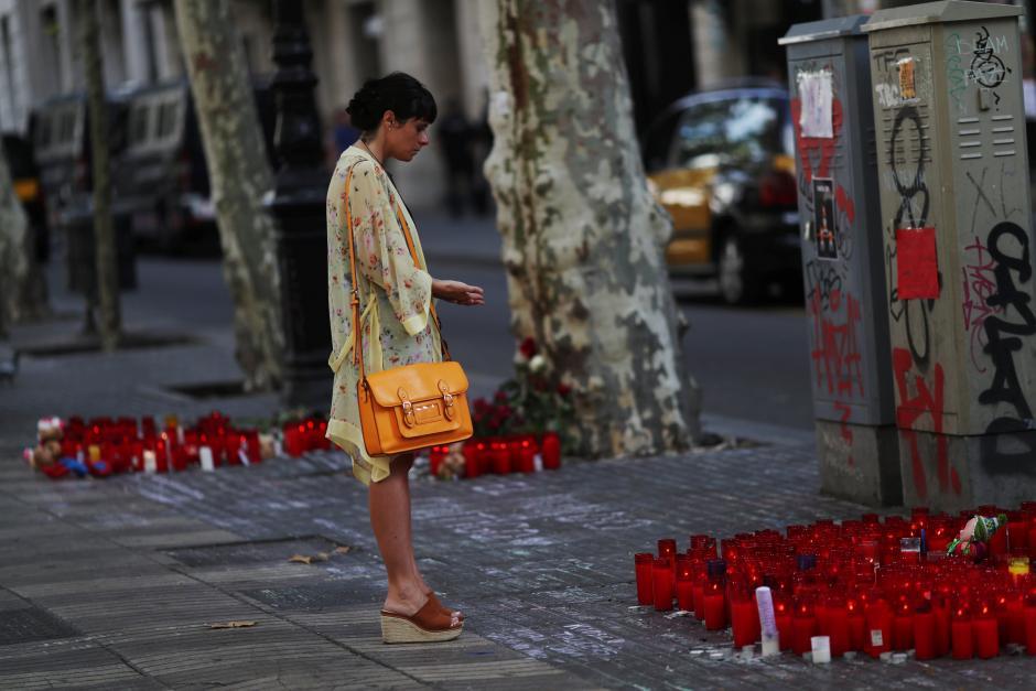 A woman reacts at an impromptu memorial where a van crashed into pedestrians at Las Ramblas in Barcelona, Spain 