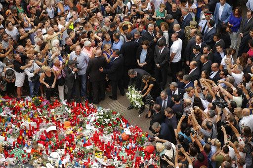 Spain's King Felipe and Queen Letizia paying respect at a memorial tribute of flowers