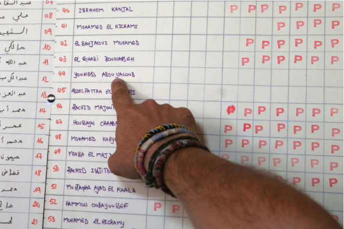 A journalist points the name of Younes Abouyaaqoub in a table of voluntary payments for the expenses of the mosque (where he didn't contribute) at a mosque where imam Abdelbaki Es Satty preached in Ripoll, north of Barcelona, Spain August 20, 2017.