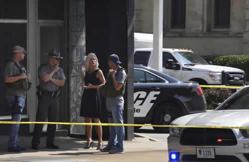 Officials consult near the crime scene at the Huntington Bank, next to the Courthouse.