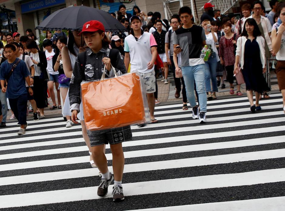 A woman carries a shopping bag at a shopping district in Tokyo, Japan August 14, 2017