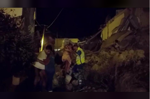 A woman is helped out of debris and rubble after an earthquake hit the island of Ischia, off the coast of Naples, Italy August 21, 2017, in this still image taken from video