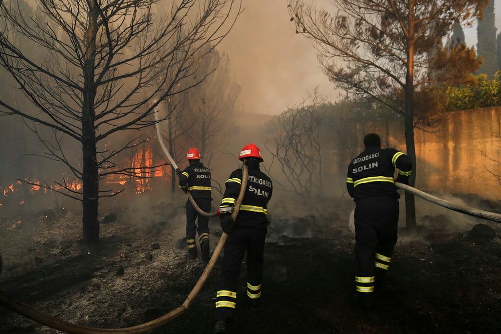 Firefighters try to extinguish a wildfire in the village of Mravince near Split, Croatia.