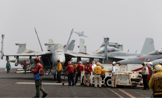 THE PERSIAN Gulf, an Iranian drone crosses the path of American fighter jets lining up to land on the USS Nimitz