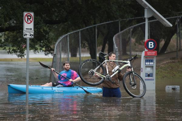 Houston residents navigate a flooded street that has been inundated with water from Hurricane Harvey