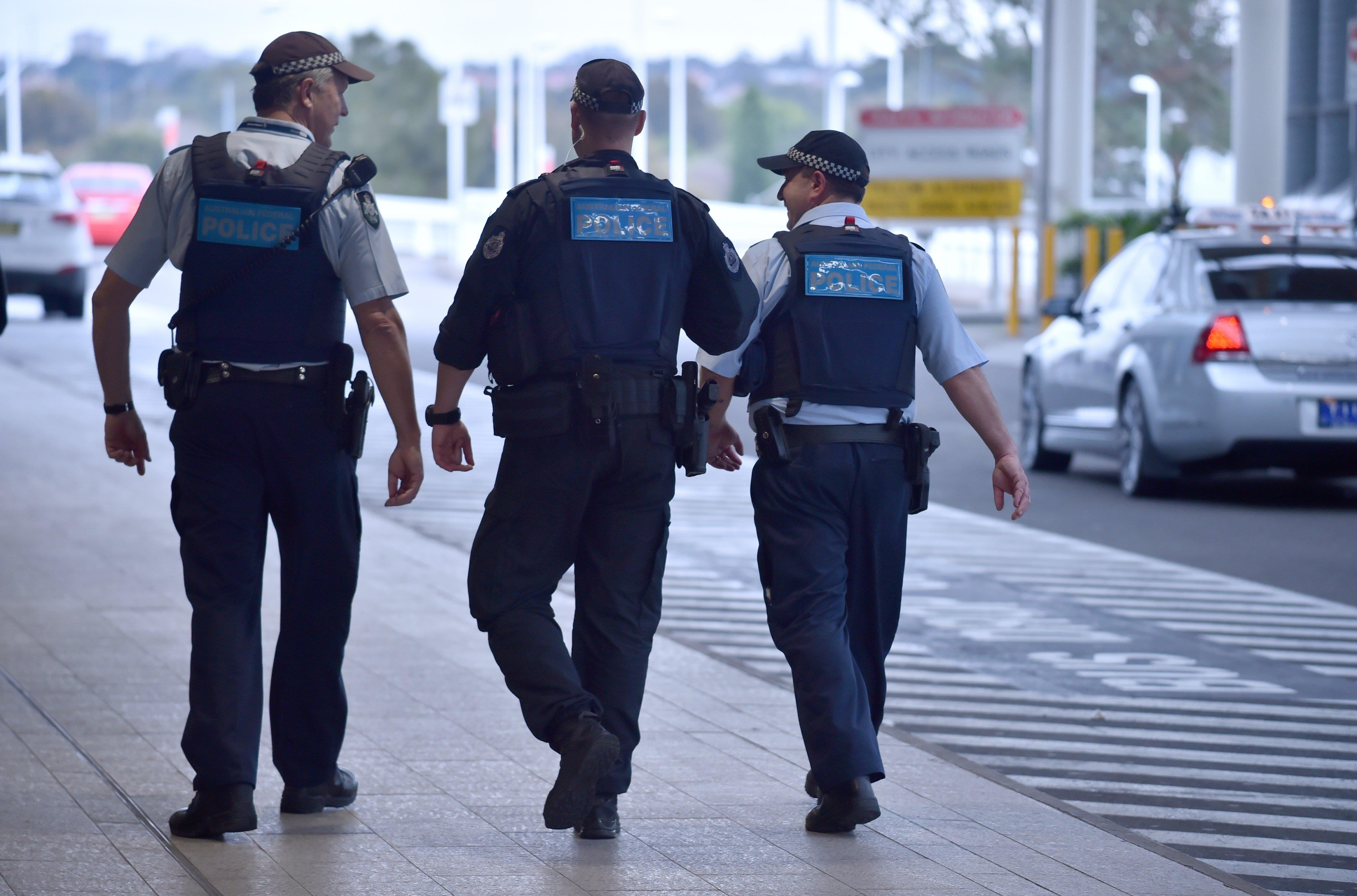Police walk outside the international terminal Sydney Airport.