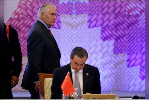 U.S. State Secretary Rex Tillerson, left, passes by the table of Chinese Foreign Minister Wang Yi at the start of the 7th East Asia Summit Foreign Ministers' Meeting 