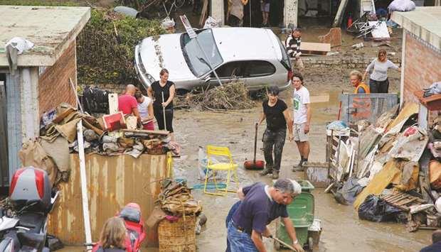  People clean mud following floods in Livorno, Italy.