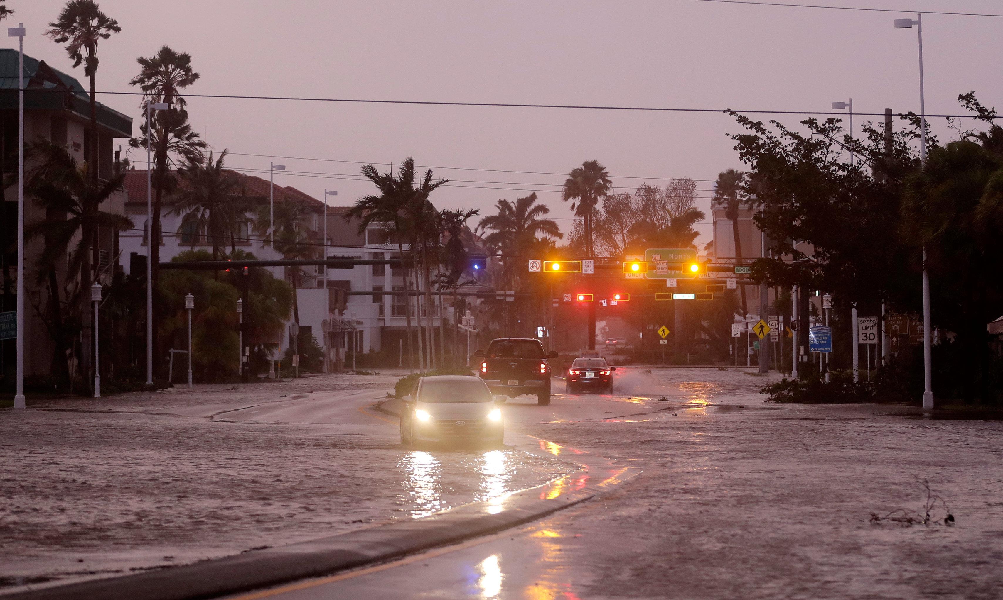 Vehicles drive through a flooded street as Hurricane Irma passes through Naples, Fla., Sunday, Sept. 10, 2017 