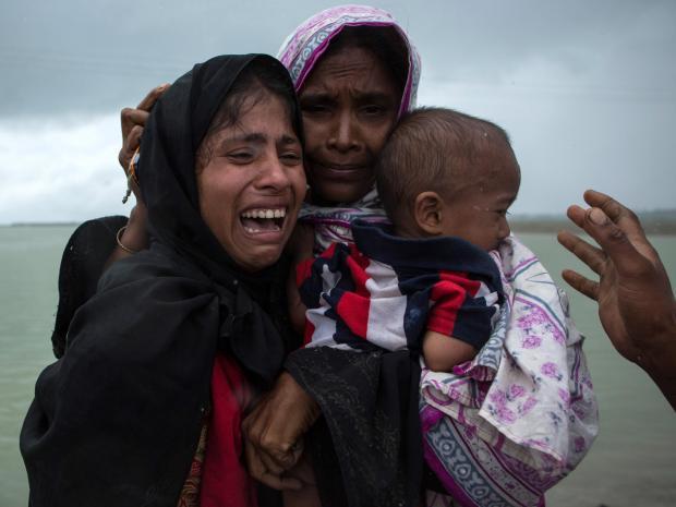 Rohingya Muslim refugees react after being re-united with each other after arriving in Whaikhyang, Bangladesh on a boat from Burma