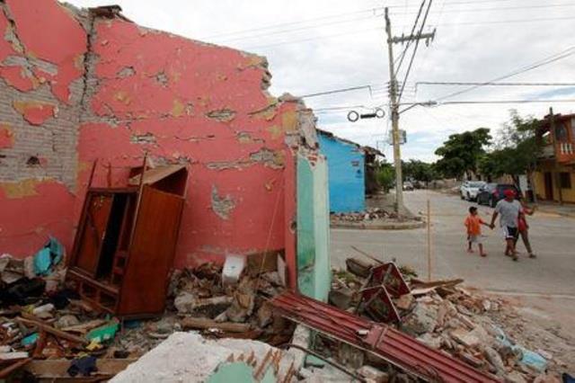 Residents walk next to a house destroyed by the earthquake that struck the southern coast of Mexico late on Thursday, in Ixtaltepec, Mexico, September 10, 2017.