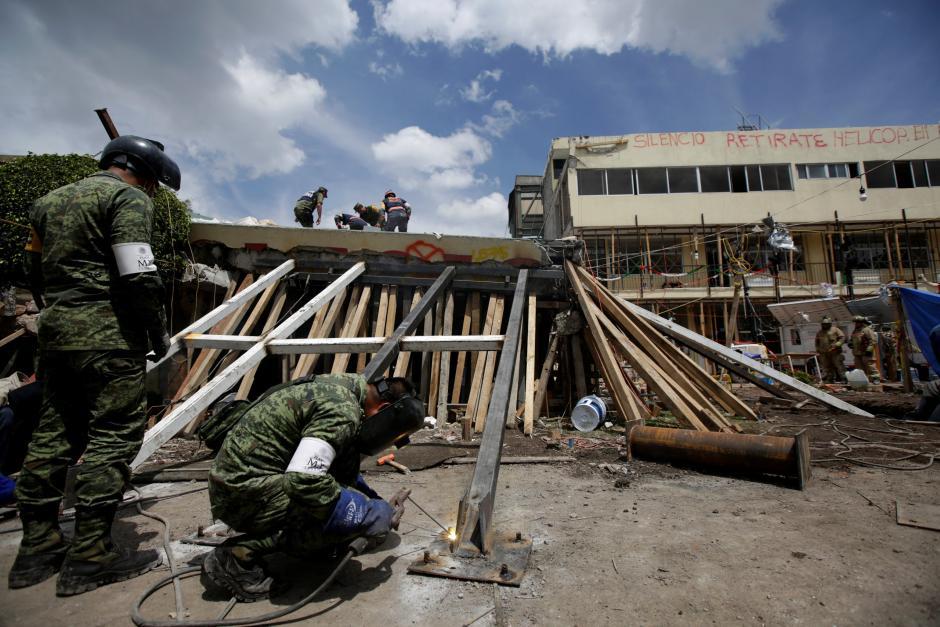 Members of a rescue team search for students amidst the rubble of a collapsed building of the Enrique Rebsamen school after an earthquake, Mexico September 22, 2017