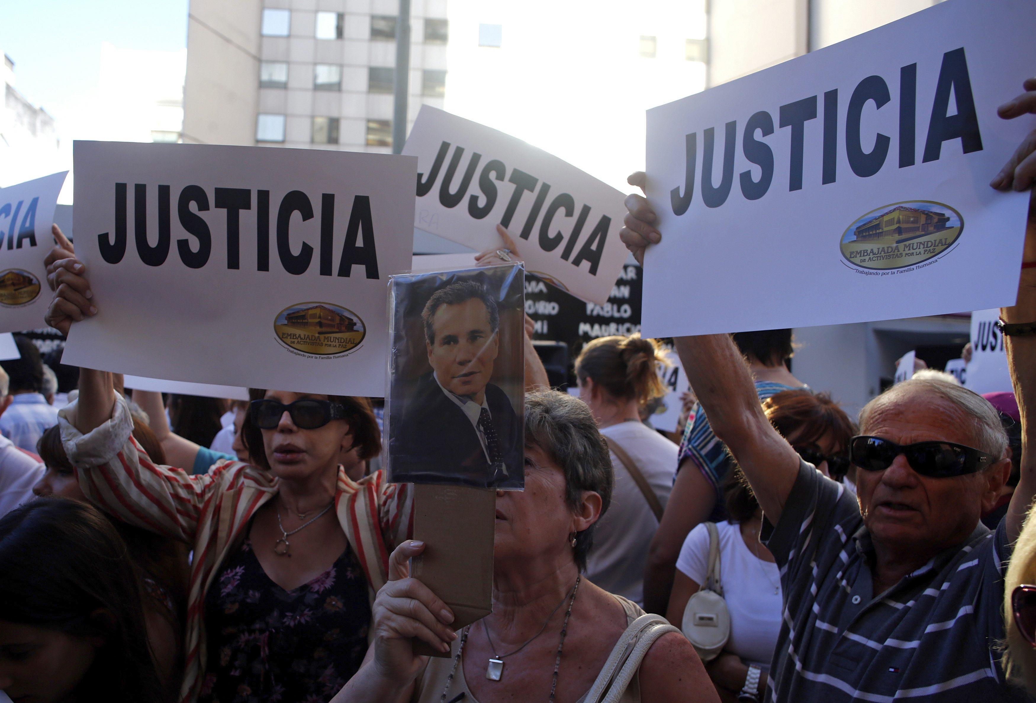 A woman holds up a picture of the late Argentine prosecutor Alberto Nisman during a demonstration Wednesday in Buenos Aires during a demonstration over his death.