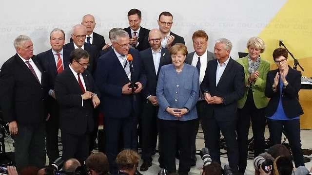 Angela Merkel hangs on to power but bleeds support to surging far right