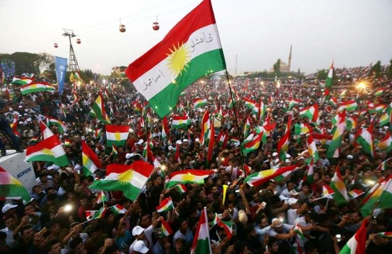 Iraqi Kurds fly Kurdish flags during an event to urge people to vote in the upcoming independence referendum in Arbil,