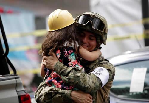 A girl hugs a Mexican marine officer as she offers hugs to people near the site of a collapsed building after an earthquake, in Mexico City, on Sept 25 2017