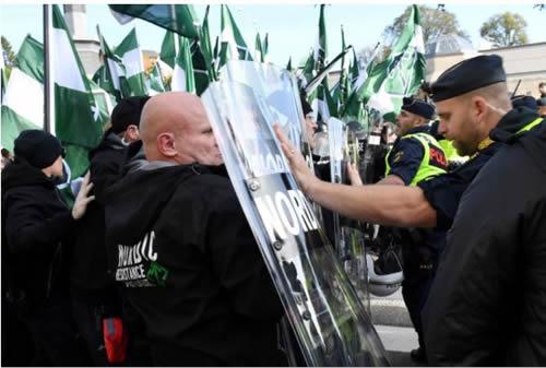 Police officers stop NMR demonstrators from trying to walk along a forbidden street during the Nordic Resistance Movement (NMR) march in central Gothenburg, Sweden September 30, 2017.