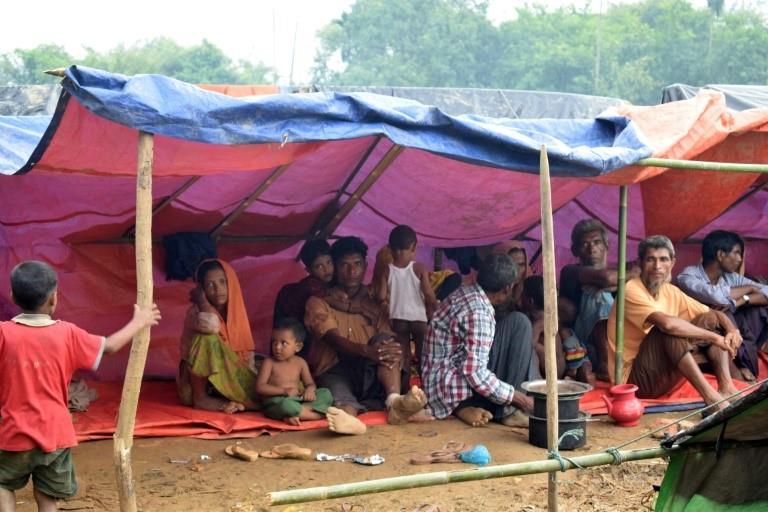 Rohingya refugees rest under a tent in a meadow in Ukhiya, Bangladesh