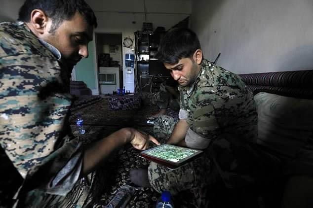 SDF fighters use an iPad to map out Islamic State group positions in Raqa on on September 3, 2017 as they battle to seize the city from the jihadist group