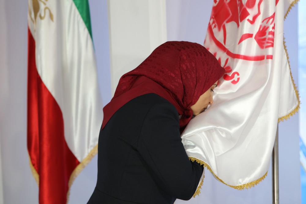  Ms. Zahra Merrikhi paying respect to the PMOI Emblem and Iranian flag