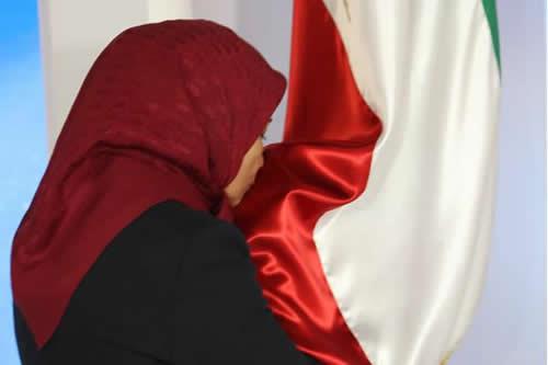 Ms. Zahra Merrikhi paying respect to the Iranian flag