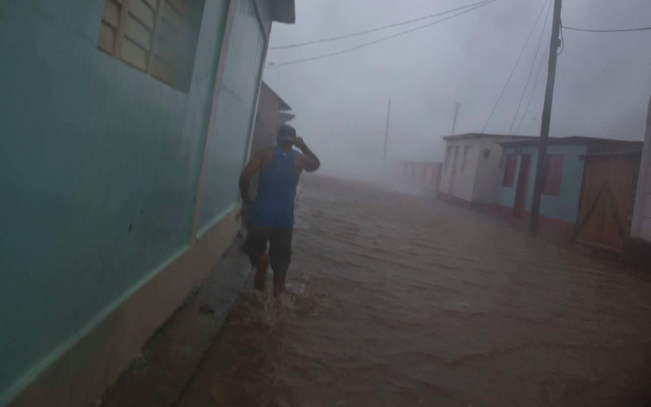  A resident runs in as flooded street as Hurricane Matthew roars over Baracoa