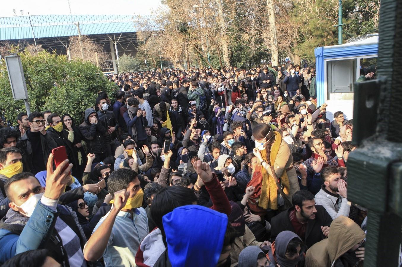 Iranian university students attend a protest inside Tehran University while anti-riot Iranian police prevent them to join other protestors, in Tehran, Iran, Saturday, Dec. 30, 2017
