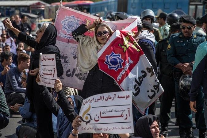 Women hold signs denouncing financial institutions during a protest driven by anger over economic problems in Tehran last October. 