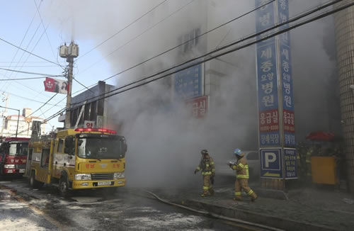 Firefighters work as smoke billows from a hospital in Miryang, South Korea, Friday, Jan. 26, 2018