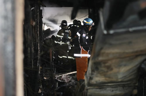 Firefighters inspect a burnt hospital after a fire in Miryang, South Korea, Friday, Jan. 26, 2018.