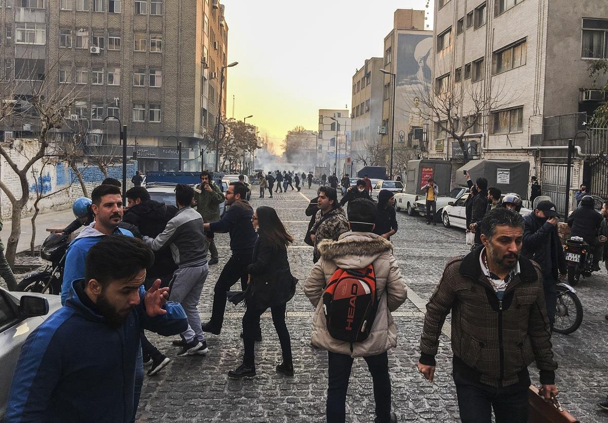 People are affected by tear gas fired by anti-riot Iranian police to disperse demonstrators in a protest over Iran’s weak economy, in Tehran, Iran.