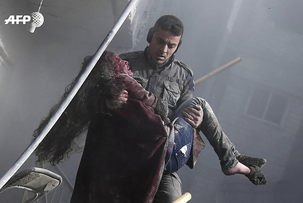A rescuer emerge from the rubble carrying a child