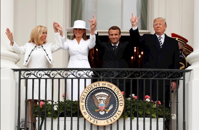 U.S. President Donald Trump, first lady Melania Trump, French President Emmanuel Macron and his wife Brigitte Macron (L) raise their linked hands in the air