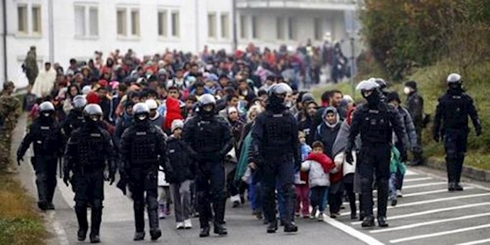  'Slovenian police escort migrants walking towards the Austrian border near the village of Sentilj, Slovenia, October 25, 2015.'