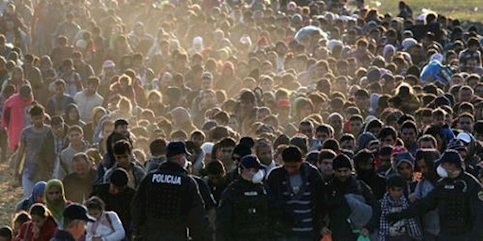  'Migrants and refugees are escorted by Slovenian soldiers and police officers at border near Rigonce, Slovenia, on October 26, 2015 '