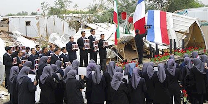  'Residents of Camp Liberty standing in the ruins of their camp after deadly missile attack'