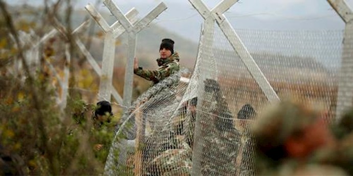  'Macedonian soldiers erect a metal fence on the border with Greece, near Gevgelija'