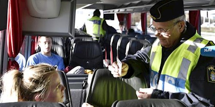  'A police officer checks passports inside a bus at Lernacken, on the Swedish side of the Oresund strait, November 12, 2015'